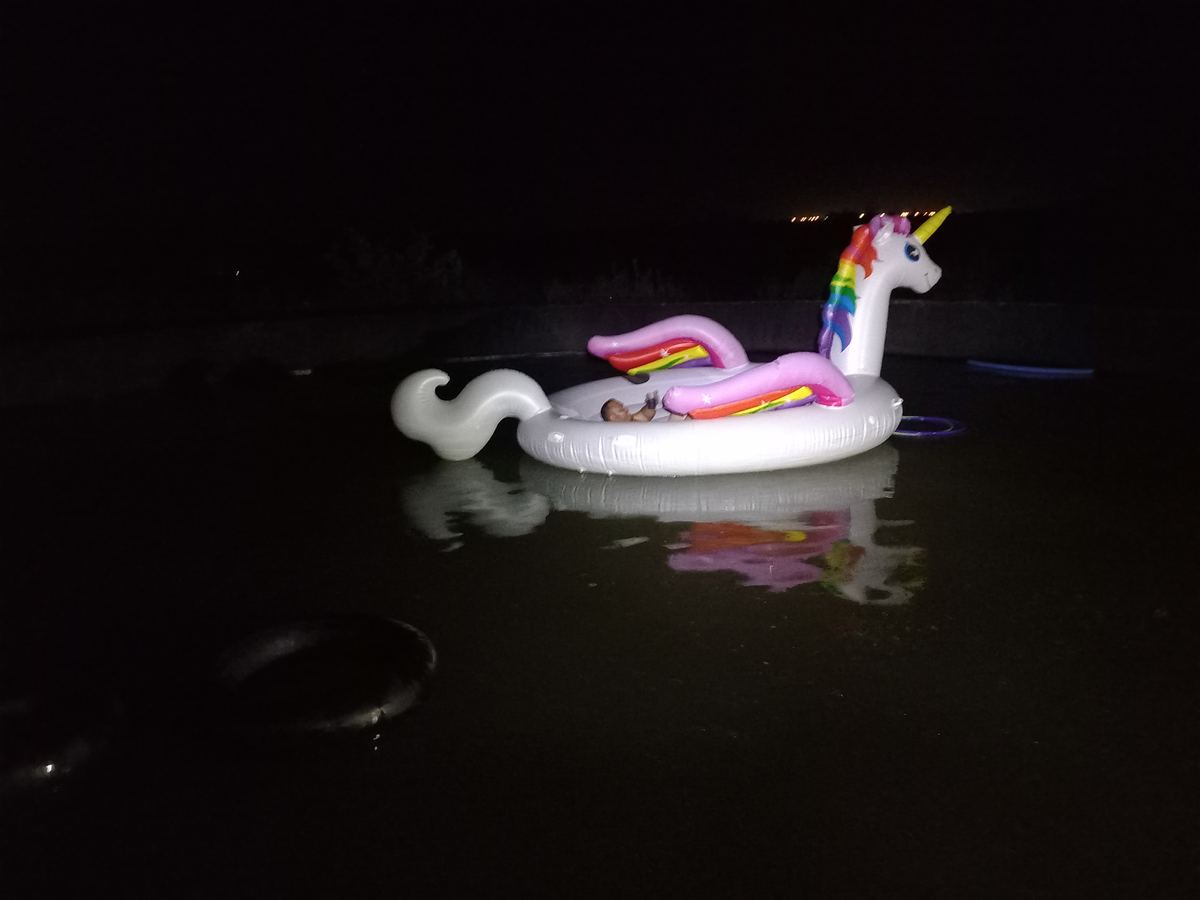 Unicorn pool float lit up at night